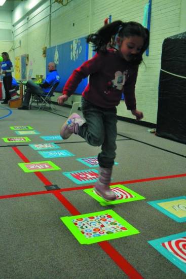 Naomi Jaquez, a first grade student, hops along the Dr. Seuss themed hopscotch as she waited, anxiously, for a book.