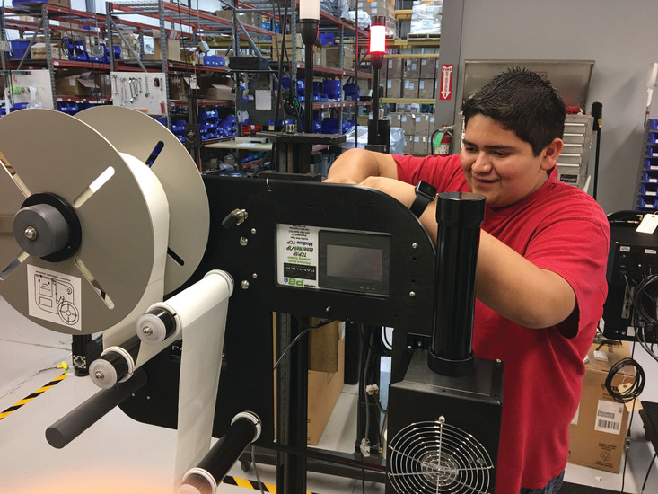Kendrick Castillo, 16, works on a label printing product at Panther Industries, 8990 Barrons Blvd. Castillo is one of three STEM School and Academy students involved in the company’s first intern program this summer that lasts eight weeks.