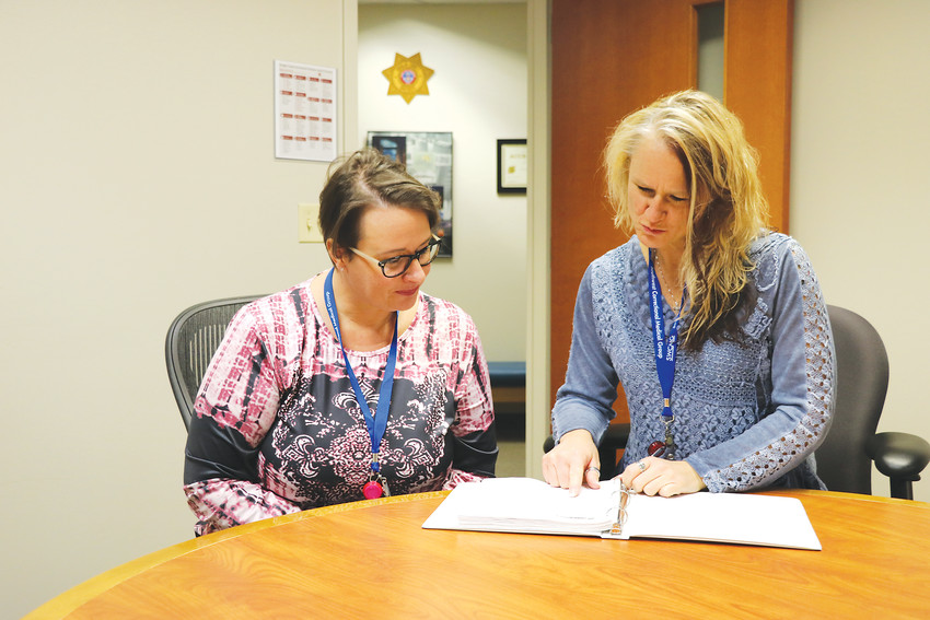 Shauna Shipps, left, licensed professional mental health clinician, and Jennifer Glenn, health services administrator, review paperwork at the Douglas County Justice Center. The two work in the jail, which in recent years has seen an overwhelming number of inmates with mental illness. “There are just no resources,” Glenn said. “You have mentally ill people on the streets, not taking their medication, and then they commit a crime.”