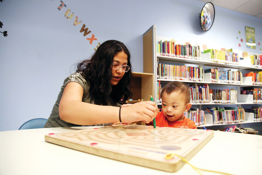 Leslie Belmontes playes with her son, Aaron, at the Bear Valley Branch Library in Denver.