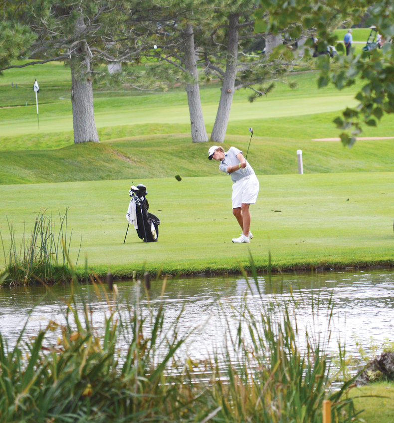 Arapahoe's Caleb Busta hits an approach shot over a pond on the 18th hole on Oct. 2 in the final round of the Class 5A State High School golf tournament held at the Colorado Springs County Club. Busta tied for 10th place with teammate Riley Rottschaefer and Arapahoe finished third in the team standings.