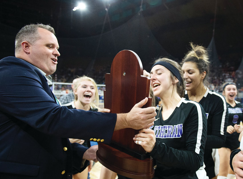 Lutheran's Abby Akers accepts the Championship trophy from CHSAA official Caleb Coates after defeating Colorado Springs Christian 3-1 for the 3A State Final on Nov. 10 at the Denver Coliseum.
