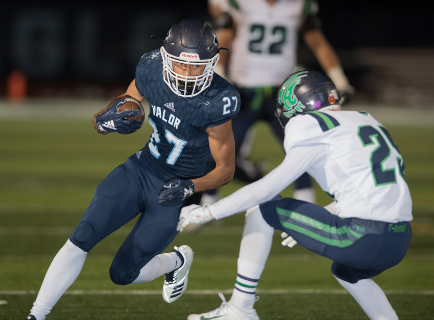 Valor Christian's Gavin Sawchuck (27) tries to get by ThunderRidge defender Jake Heggie (25).  Sawchuck ran wild, racking up 113 yards and five TDs on 24 carries as his Eagles ended up on top winning 34-7 Friday night at Valor Stadium.  Up next, they face Grandview in one of the 5A semifinals on Saturday. Photo by Paul DiSalvo