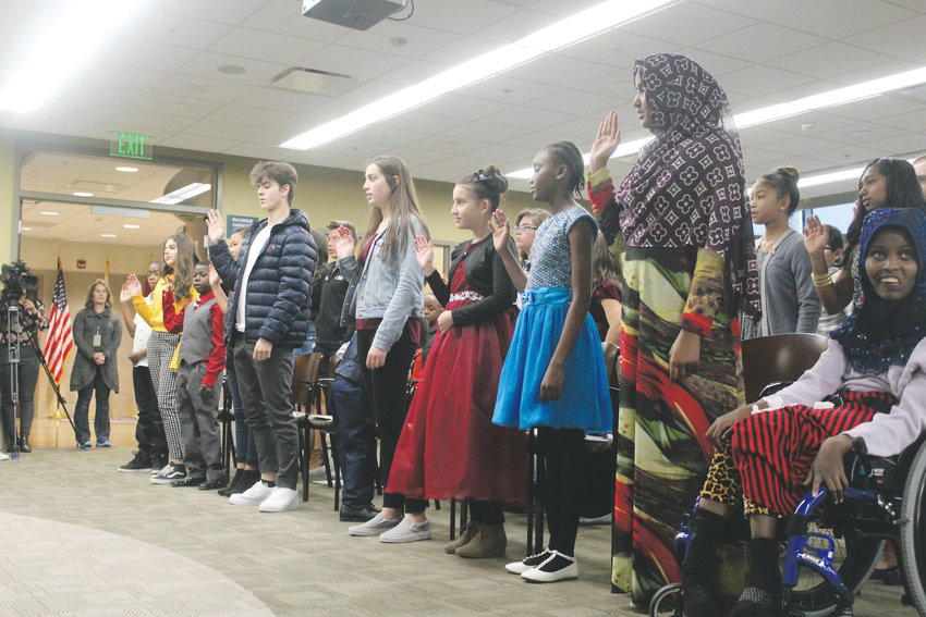 A group of 51 children are repeat an oath of allegiance prior to becoming U.S. citizens through the process of naturalization Nov. 30 in Centennial.