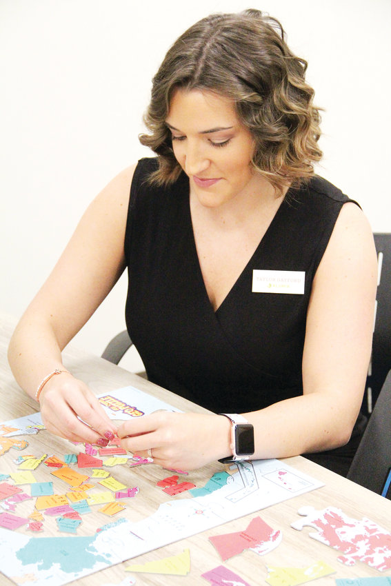 Taylor Gayford, education coordinator at Alumia Institute, plays with a geography-based activity Dec. 18 in a room at the campus centered on learning and interaction. It’s where members can learn “new skills, new things about new people,” Gayford said. “I want this to be the recess of the day.”