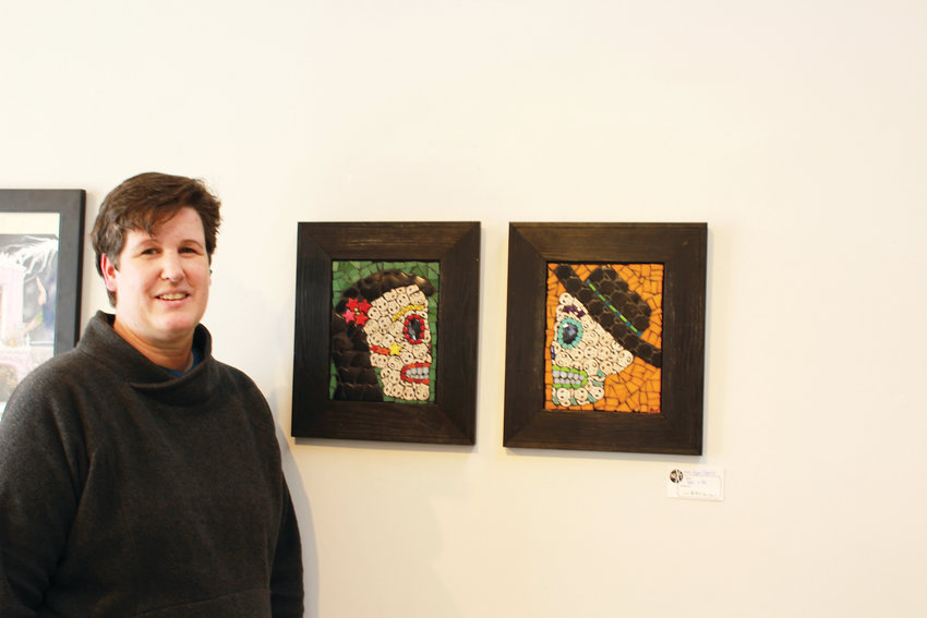 Pam Farris poses next to two of her paintings.