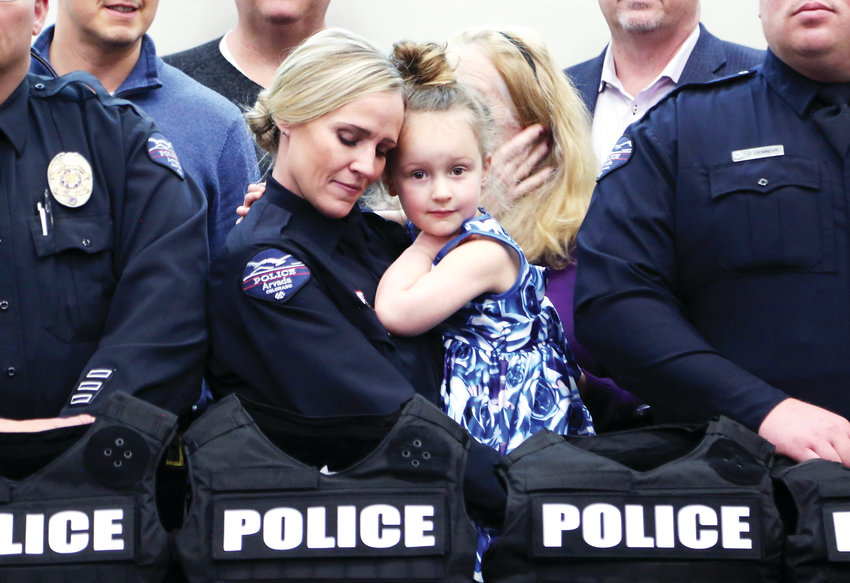 Arvada Police Officer Melinda Rommereim holds her four-year-old daughter, Paisley, after receiving her armor kit from SHIELD 616.