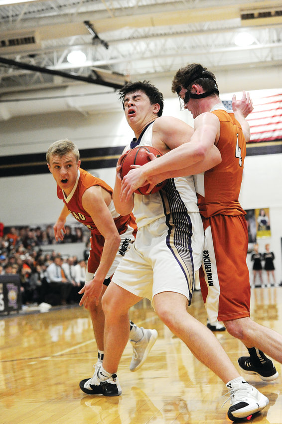 Holy Family senior forward Kyle Helbig, is fouled by Mead's David Wilhelm, right, during third quarter action of a CHSAA Boys 4A Great 8 playoff game March 2, at Holy Family High School in Broomfield. At left, is Mead's Will Maher. The Tigers earned a Boys 4A Final Four berth, by defeating Mead, 63-54. They'll meet top seed Lewis-Palmer on Friday, March 8 at the Denver Coliseum.