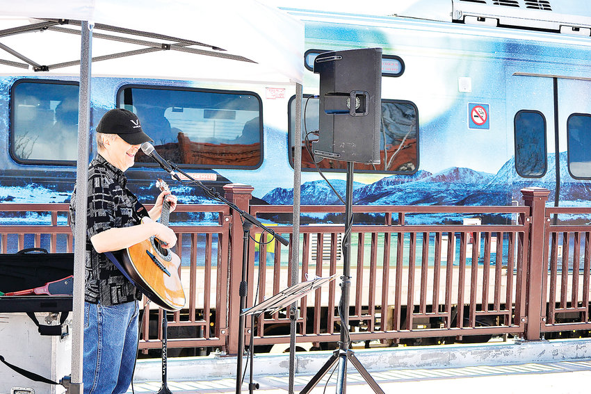 Jamie Krutz sings songs about trains as the G-Line commuter rail passes behind him. Krutz was one of several musicians to perform throughout the day Saturday, April 27, to celebrate the train's opening.