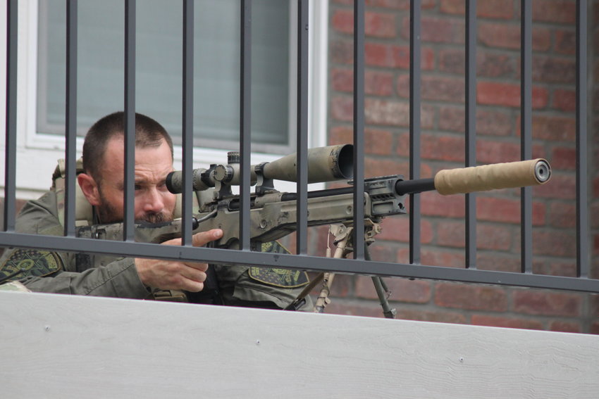 An Arapahoe County sheriff's deputy on the balcony of an apartment building across the street from the school trains his weapon on one of the doorways of the school at about 3 p.m. Tuesday.