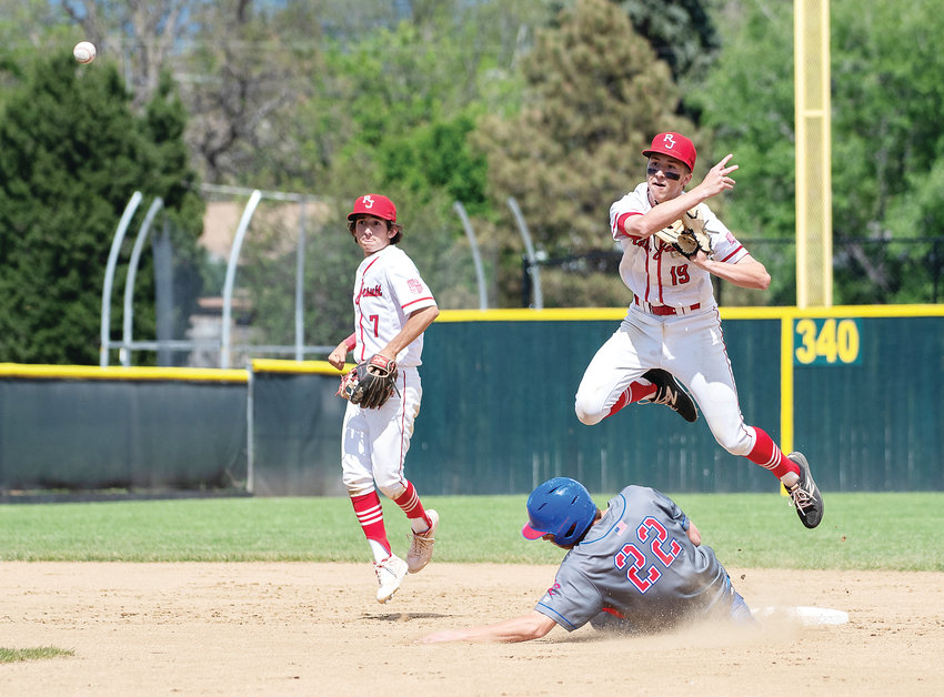 Regis Jesuit’s Hank Galan leaps to avoid a collision with Cherry Creek’s Jack Moss at second base. After a nearly two-hour rain delay, Regis won 8-3 in the 5A title game at All-City Field.