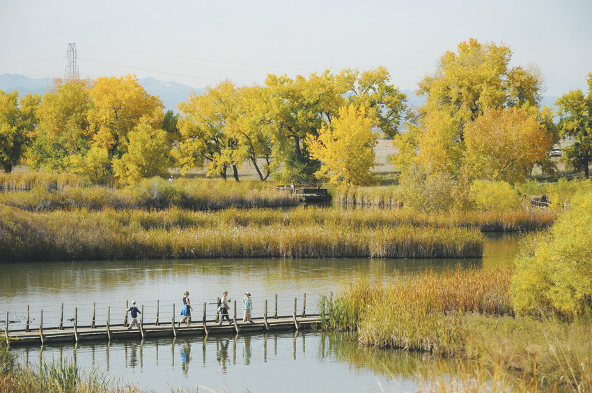People walk on the Lake Mary floating boardwalk at Rocky Mountain Arsenal National Wildlife Refuge in the Commerce City area.