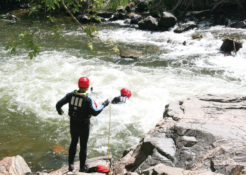 As part of a training to earn a swift water rescue technician certification, two firefighters perform a mock rescue in Clear Creek while another spots from the bank. Fifteen firefighters participated in the training, who came from West Metro Fire Rescue, South Metro Fire Rescue, Arvada Fire Department and Westminster Fire Department.
