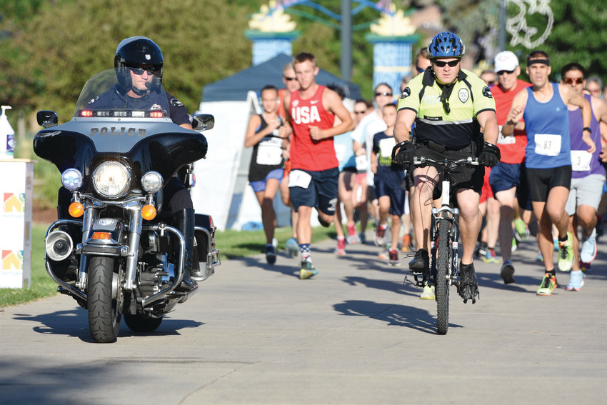 Northglenn Police escort runners at the start of the Firecrackers and Flapjacks Four Mile Run on July 4th at E. B. Rains, Jr. Park in Northglenn. The annual run was part of multiple activities conducted by the city on Independence Day.