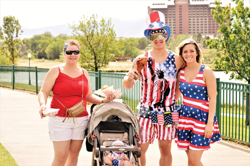 Left to right, Meg Haderlie, 43, Thomas Haderlie, 22, Shannon Rodriguez, 23 with four-month-old Serenity Haderlie in the baby carriage, are decked out in red, white and blue holiday finery as they make their way from the food trucks July 4 at Westminster’s City Park.