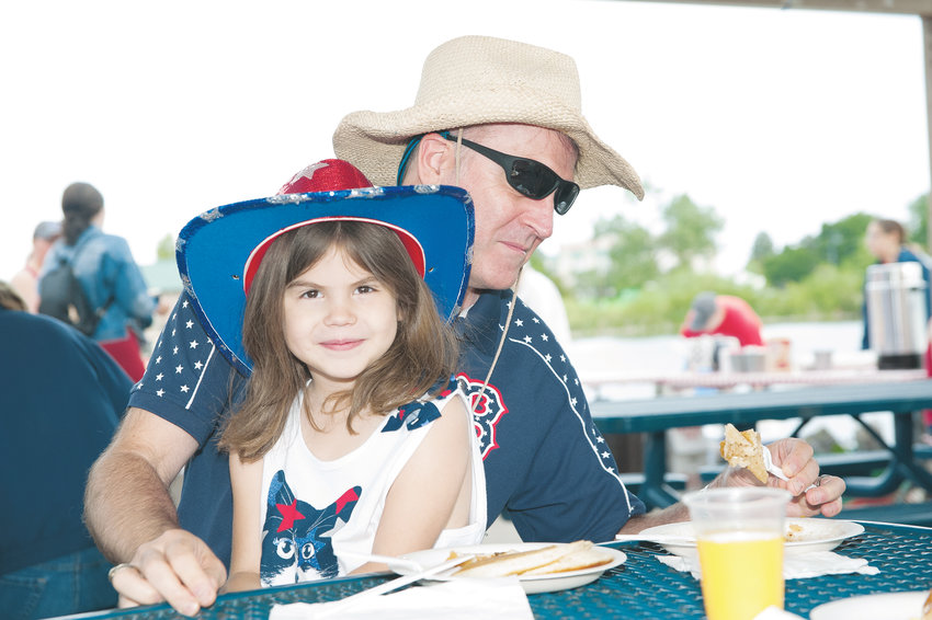 Jazmyn Wolcott, 6, and her father Jeff, of Thornton, enjoy a pancake breakfast during Boy Scout Troop 98’s annual 4th of July Pancake Breakfast, at E.B. Rains, Jr. Memorial Park. The Wolcotts recently moved to Thornton from Wilburnham, MA.