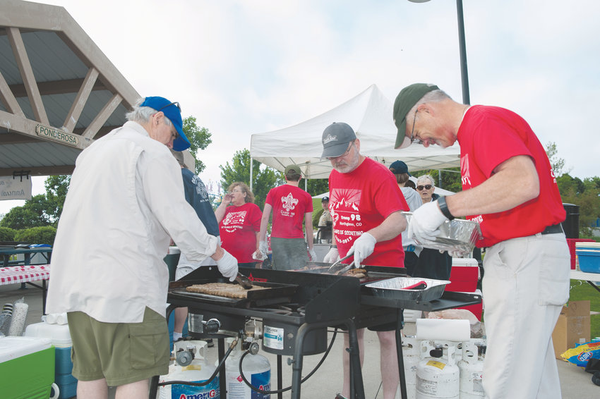 Bill Rowe, left, of Westminster, and Jeffrey Lee (center) and John Kopala, both of Thornton, cook sausages during Northglenn Boy Scout Troop 98's annual 4th of July Pancake Breakfast, at E. B. Rains, Jr. Memorial Park.