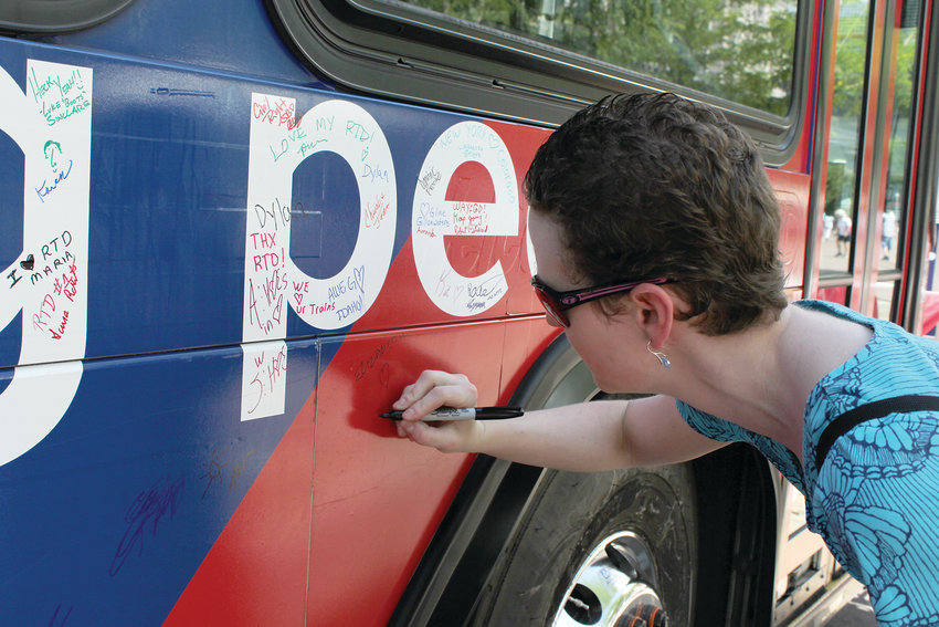 Elizabeth Bonney signs the 50th anniversary bus parked at Union Station in Denver. The Regional Transportation District celebrated the anniversary with food trucks, live music and information booths downtown.