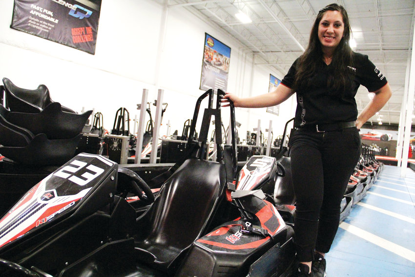 Nichole Sarno, assistant manager, stands next to karts at K1 Speed. Staff members race the karts, too, she said.