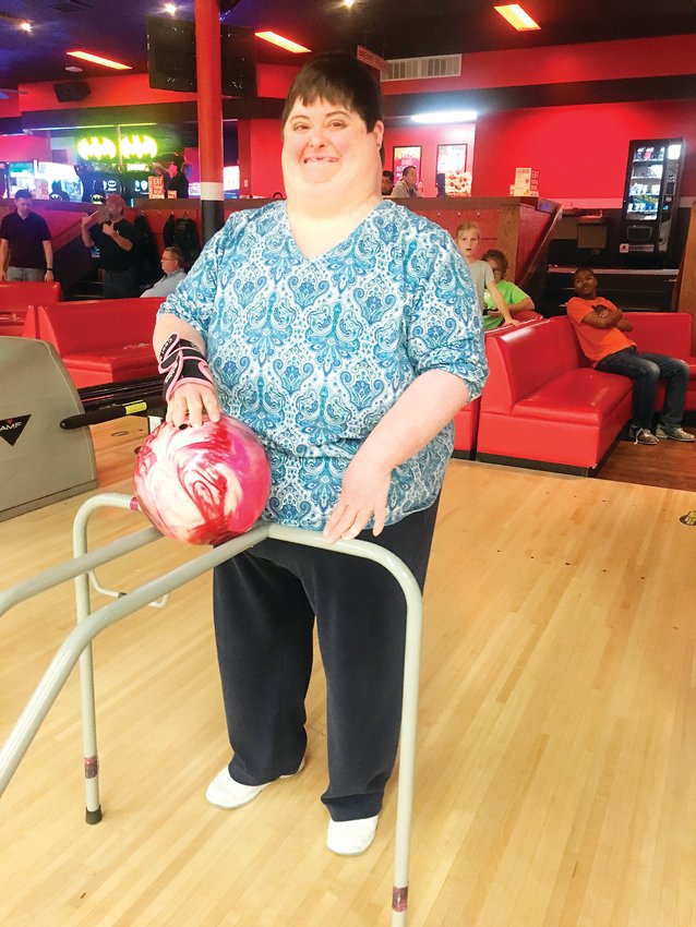 At a bowling outing with Denver Adaptive Recreation, a participant, Janna, prepares to bowl using adaptive equipment.