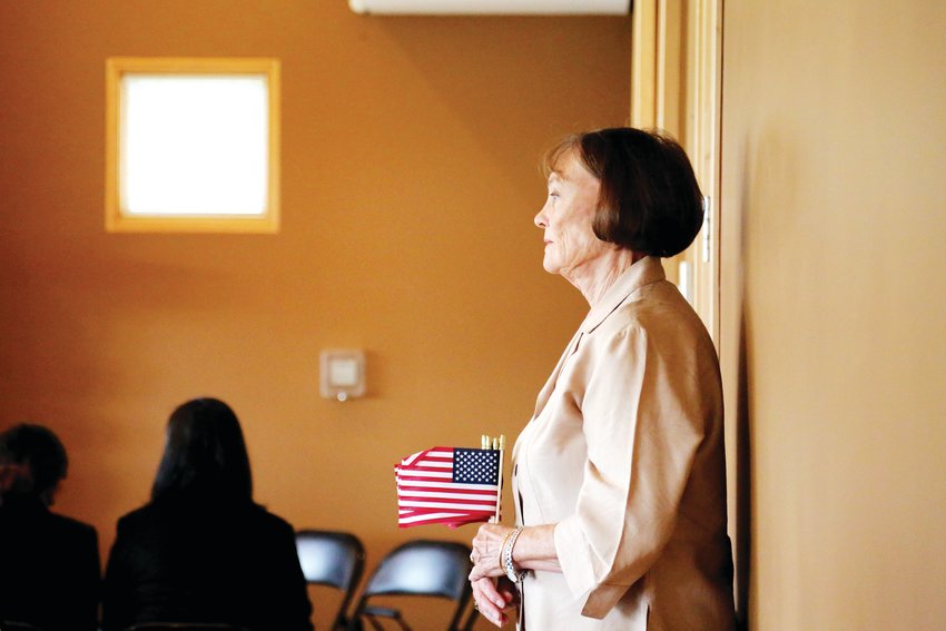 Barbara Nash, of the Peace Pipe Chapter of the Daughters of the American Revolution, waits to hand out American flags to individuals gaining U.S. citizenship at a naturalization ceremony held Sept. 6 at Four Mile Historic Park in Denver.
