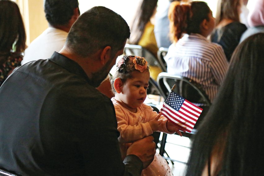 Emily Sophia Ochoa plays with an American flag while her mom becomes an U.S. citizen at a Sept. 6 naturalization ceremony.