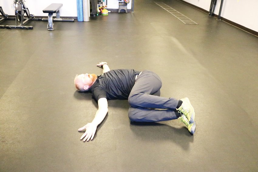 Davis demonstrates one side of a mobility exercise he recommends for skiing. One should start with knees bent in the air and then alternate sides, he said.