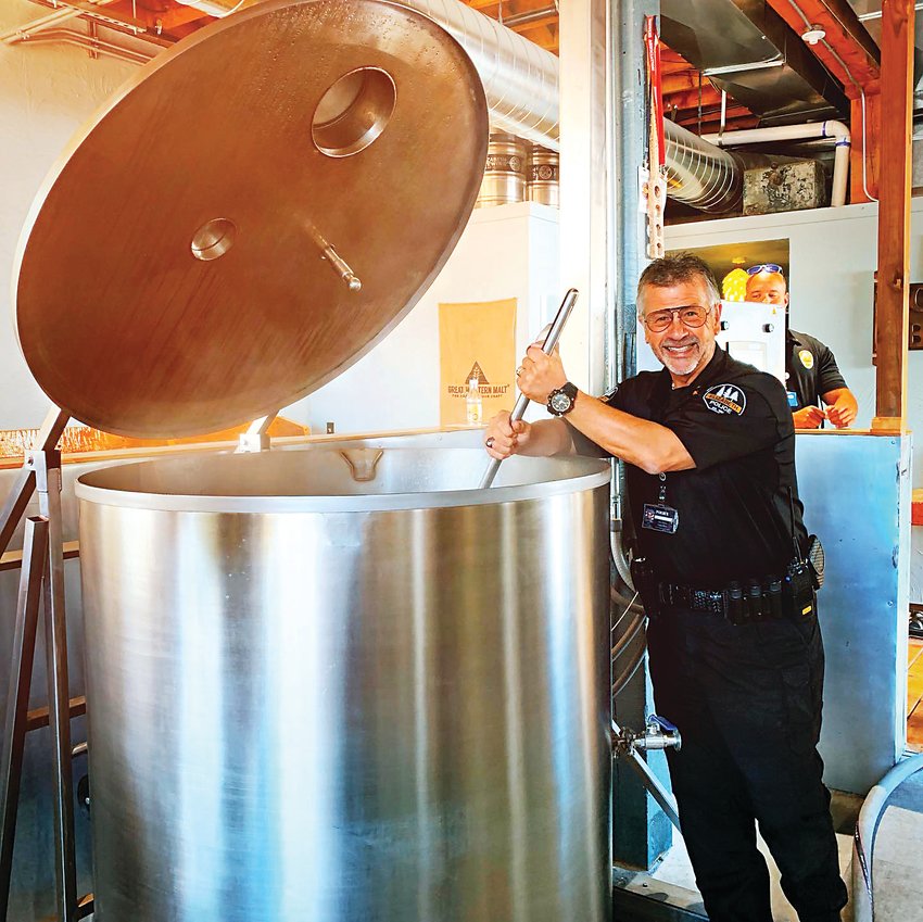 Elizabeth Chief of Police Stephen Hasler stirs the pot while helping create a specialty brew at The Elizabeth Brewing Company.