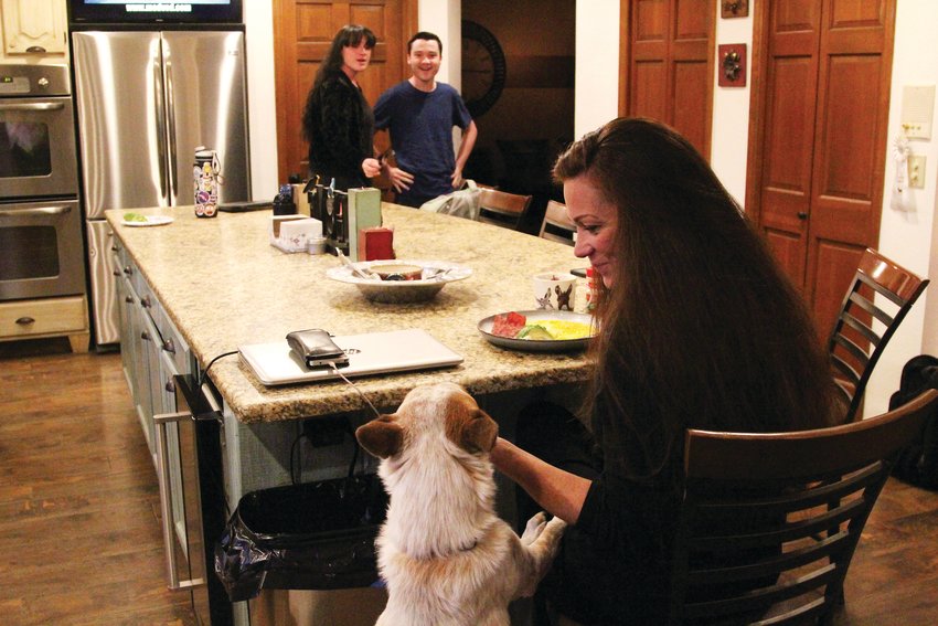 The family dog, Bindi, jumps up for a nibble from Amber Wann as she eats breakfast on Nov. 18.