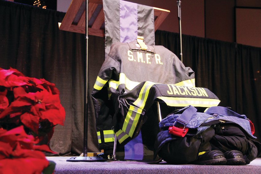The uniform of former South Metro Fire Rescue Assistant Chief Troy Jackson sits at the foot of the stage at Denver First Church, in front of the lectern for speakers.