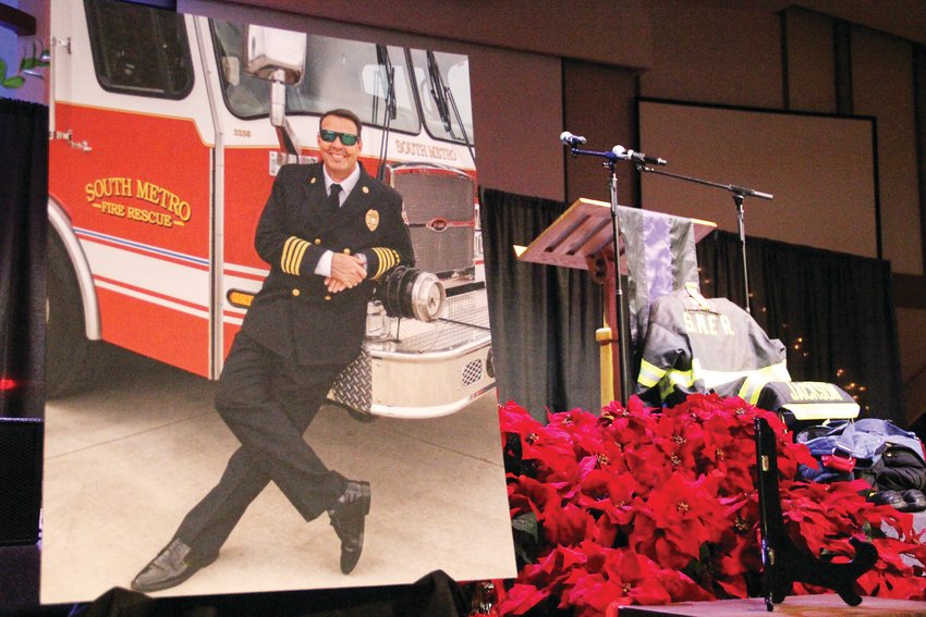 A large photo of former South Metro Fire Rescue Assistant Chief Troy Jackson sits at the foot of the stage at Denver First Church. Jackson’s uniform lay near it, at right.