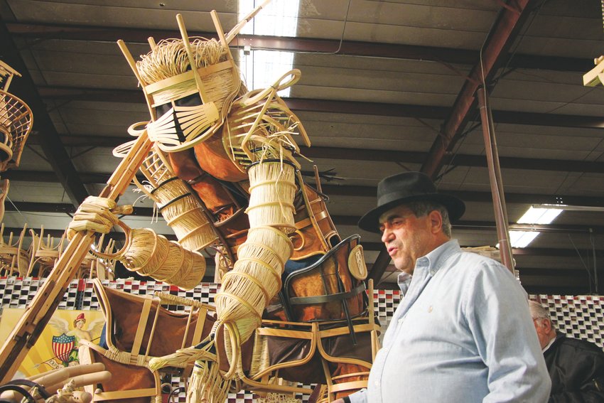 Steve Farland next to "The Creator," one of seven massive statues made of chairs. Soon to lose his warehouse space, Farland is seeking a home for all seven of his statues.