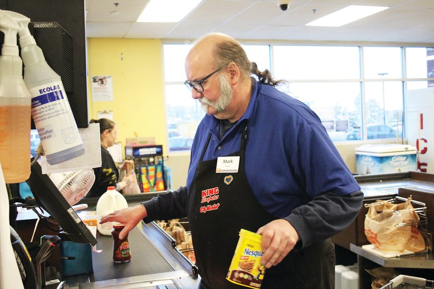 Mark Meek, a King Soopers checker, checks out chocolate milk mix. King Soopers has recently modified its hours to be open from 7 a.m. to 8 p.m. as the COVID-19 pandemic has caused grocery stores to be consistently busy in many parts of the state.
