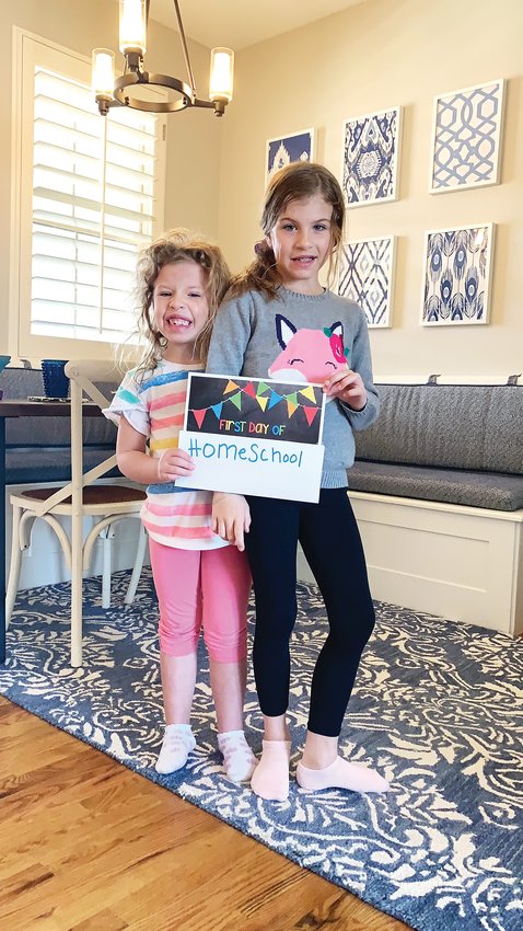 Briana and Skylar Harmon pose for a "first day of homeschool" photo as the Douglas County School District switched to remote education.