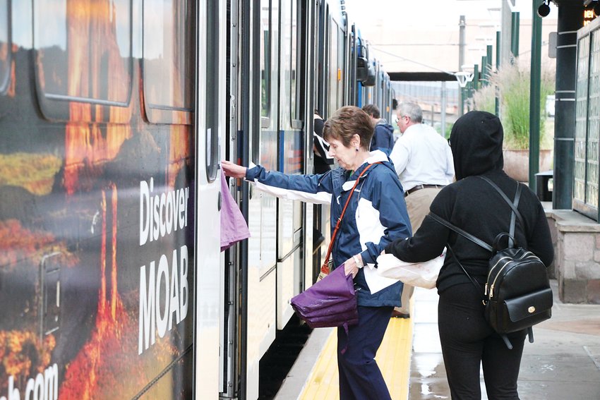 Passengers board a light rail train bound for downtown Denver from the downtown Littleton station last summer.