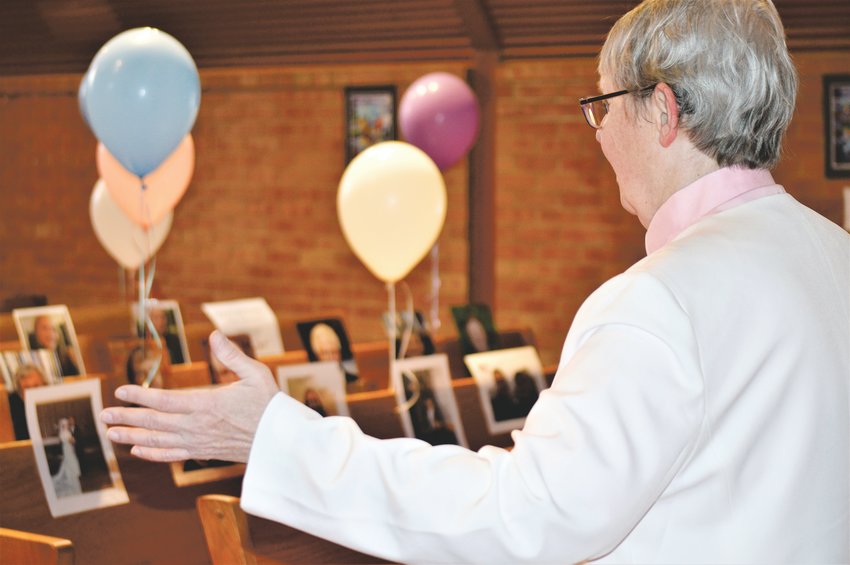 Pastor Barb Martens of  Advent Lutheran Church in Westminster takes in the balloons and photographs members of the congregation left in their places in the church’s pews before Easter Sunday service, which was shown via a live Facebook stream.