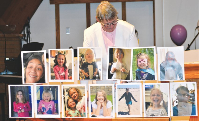 Pastor Barb Martens of Westminster’s Advent Lutheran Church looks at a collection of photographs of the children in her congregation she collected for the church’s Easter Sunday service. The virtual service was streamed to the congregation via Facebook.