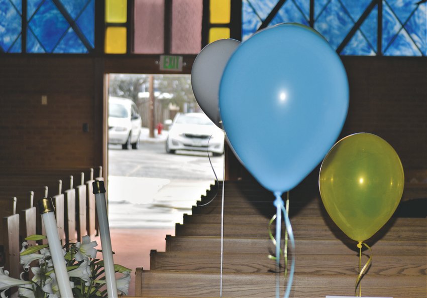 Balloons, candles and stained glass frame the door to the parking lot at Westminster’s Advent Lutheran Church. Like churches across the country, Advent Lutheran is closed to visitors but the clergy have been streaming services live to Facebook since the COVID-19 quarantines began. For Easter Sunday, members of the church filled the pews with their photographs and balloons, gathering in their cars in the lot outside to greet the clergy.