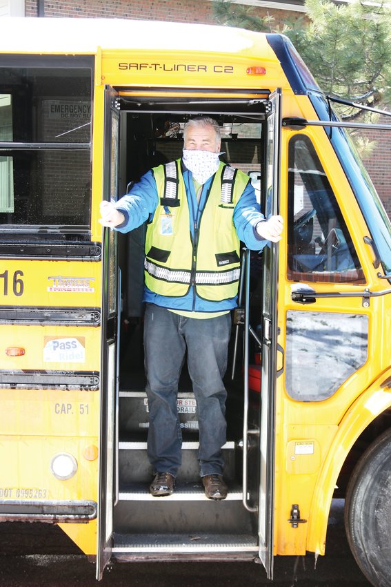 Greg Morris, a school bus driver with Denver Public Schools, opens the doors to his bus to deliver food on April 14 to students learning from home during COVID-19 pandemic.