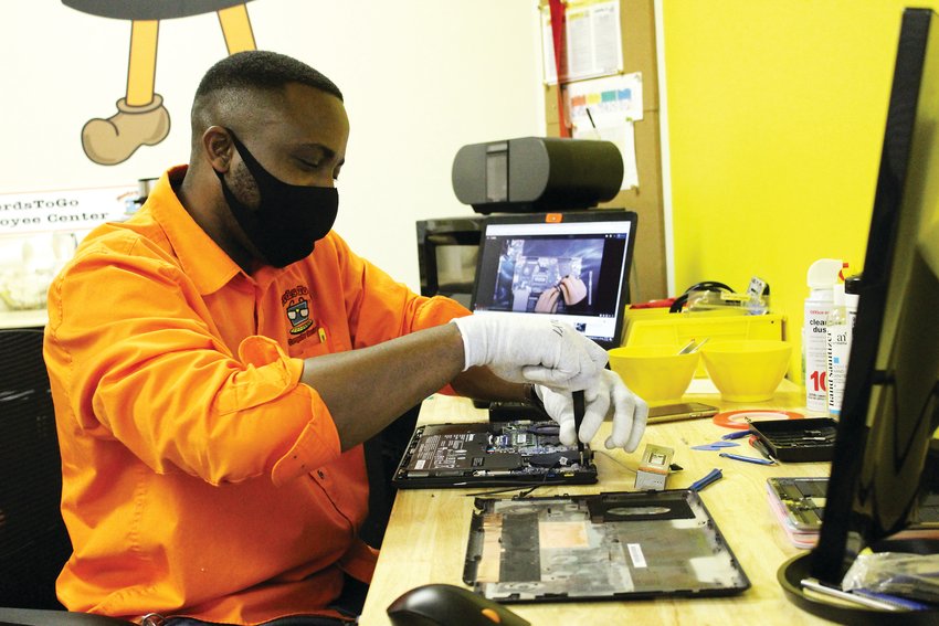 NerdsToGo technician Dre Ennis fixes a laptop at the IT office in Parker April 15.