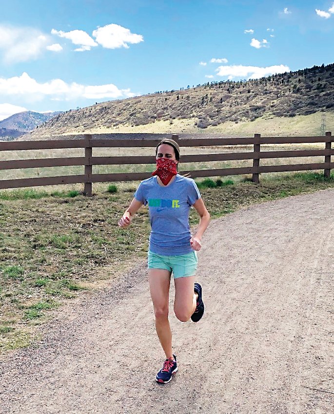 Lakewood High teacher and cross-country coach Bryn Smetana runs a trail in Littleton, wearing a cloth face covering as directed by the CDC.