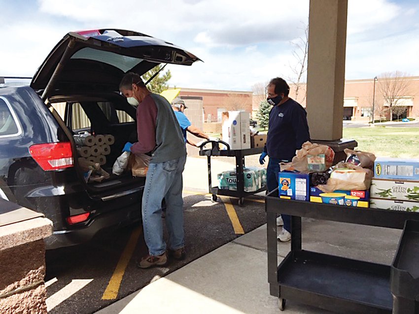 Instead of having guests come inside to get food from the Parker Task Force, volunteers are loading up their cars with the items they need while wearing masks and gloves.