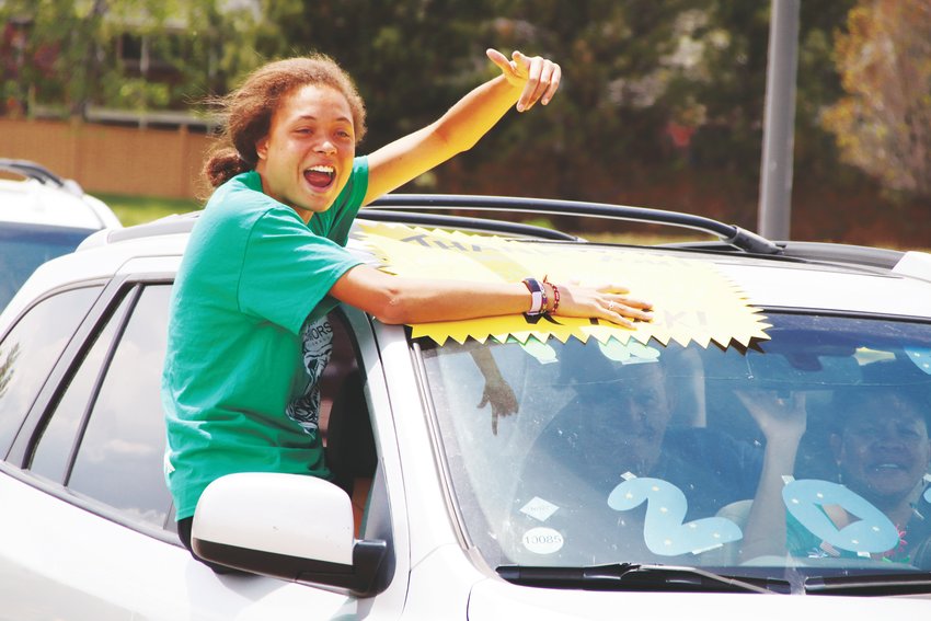 A ThunderRidge High School graduate points and smiles as she sees one of her teachers during a parade of seniors May 15.