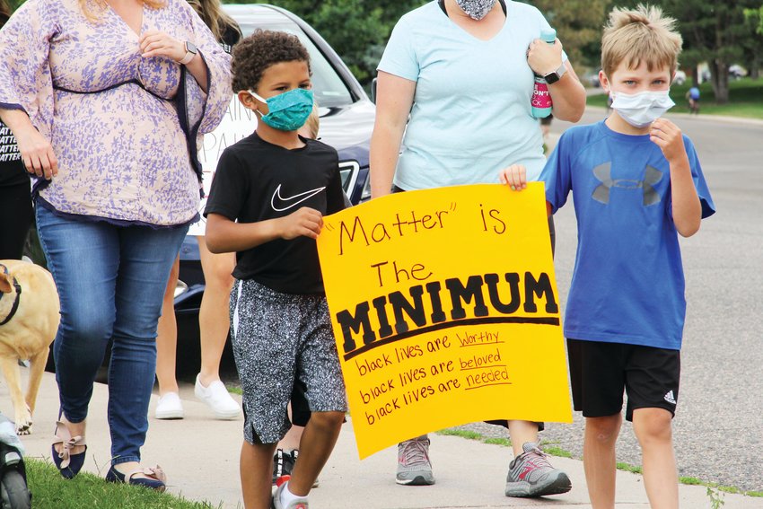 Two young children at Willow Creek Park carry a sign that read, " 'Matter' is the minimum; black lives are worthy; black lives are beloved; black lives are needed." The march came amid nearly two weeks of protests in the downtown Denver area that have featured messaging aligned with the Black Lives Matter movement, which opposes "state-sanctioned violence" against black people, along with "anti-Black racism," according to its website.