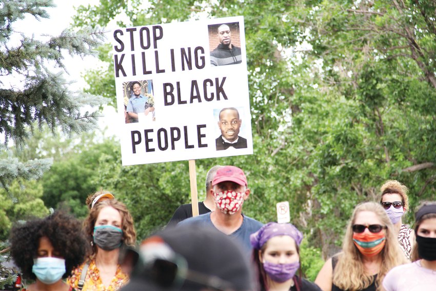 A sign with photos of George Floyd, top right; Breonna Taylor, left; and Ahmaud Arbery, lower right, black individuals who were killed in recent months in what protesters have decried as unjust deaths. It read, "Stop killing black people." The sign was one of many at a June 8 "family friendly walk for justice," as a social media post called the event.