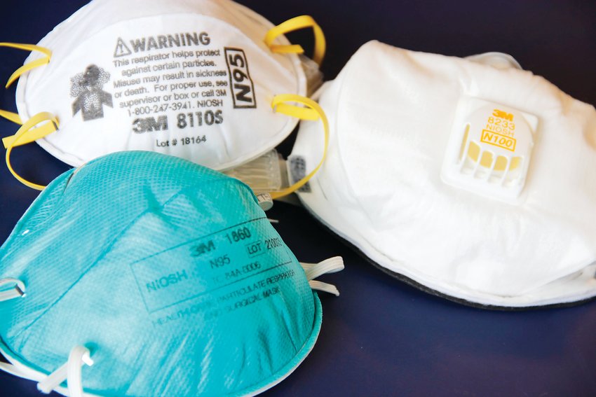 Two N95-type face masks, or respirators, at left. On right, a third respirator, an N100-type mask.