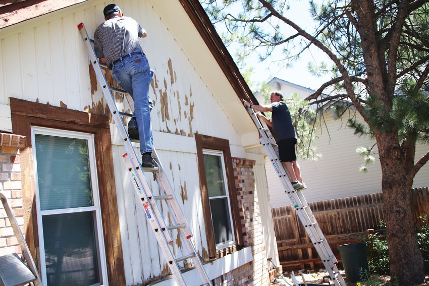 Wes Kouns’ home fell to disrepair and below standards from the local home-owners association, and a group of men from the Church of Jesus Christ of Latter-day Saints in Lone Tree have led an effort to repair the outside of Kouns’ home. Randy Jones and Tim Bishop work on one wall of Kouns’ house June 20.