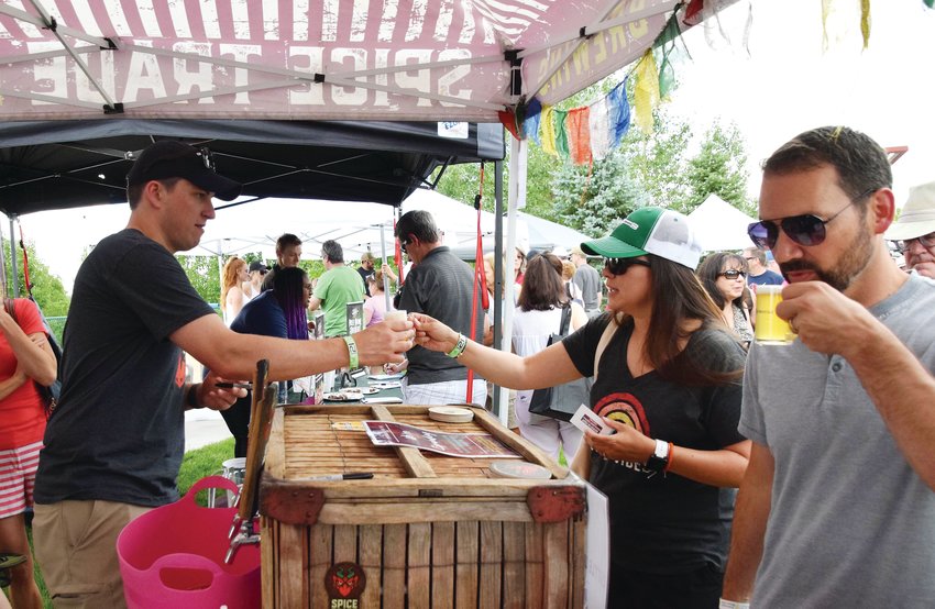 A member of the Spice Trade Brewing team handed out tasters at the 2019 Centennial Brew-N-Que. The event was canceled this year because of coronavirus concerns.