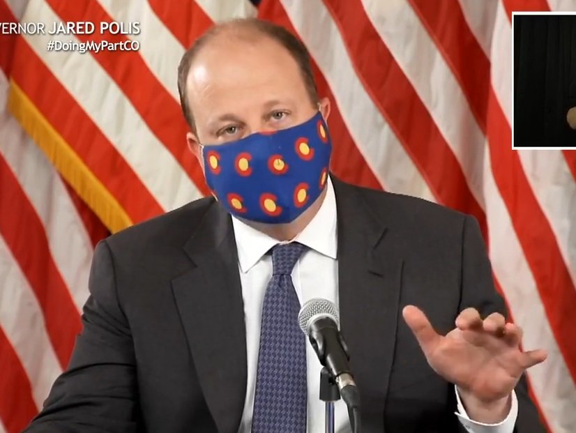 Colorado Gov. Jared Polis in July 2020 announcing the statewide order requiring those over age 10 to wear masks indoors. An interpreter for the hearing impaired appears at upper right.