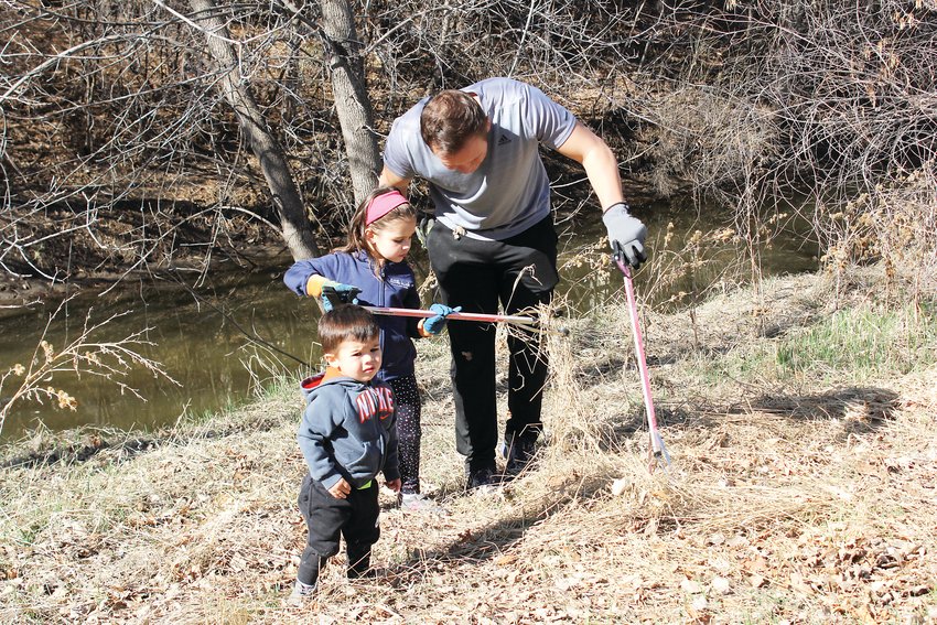 In this 2019 photo, Michael Mersmann and his two children, Ellie and Dominic, are seen picking up trash next to the High Line Canal. Mersmann said the cleanup was an opportunity to teach his children about volunteering in the community.